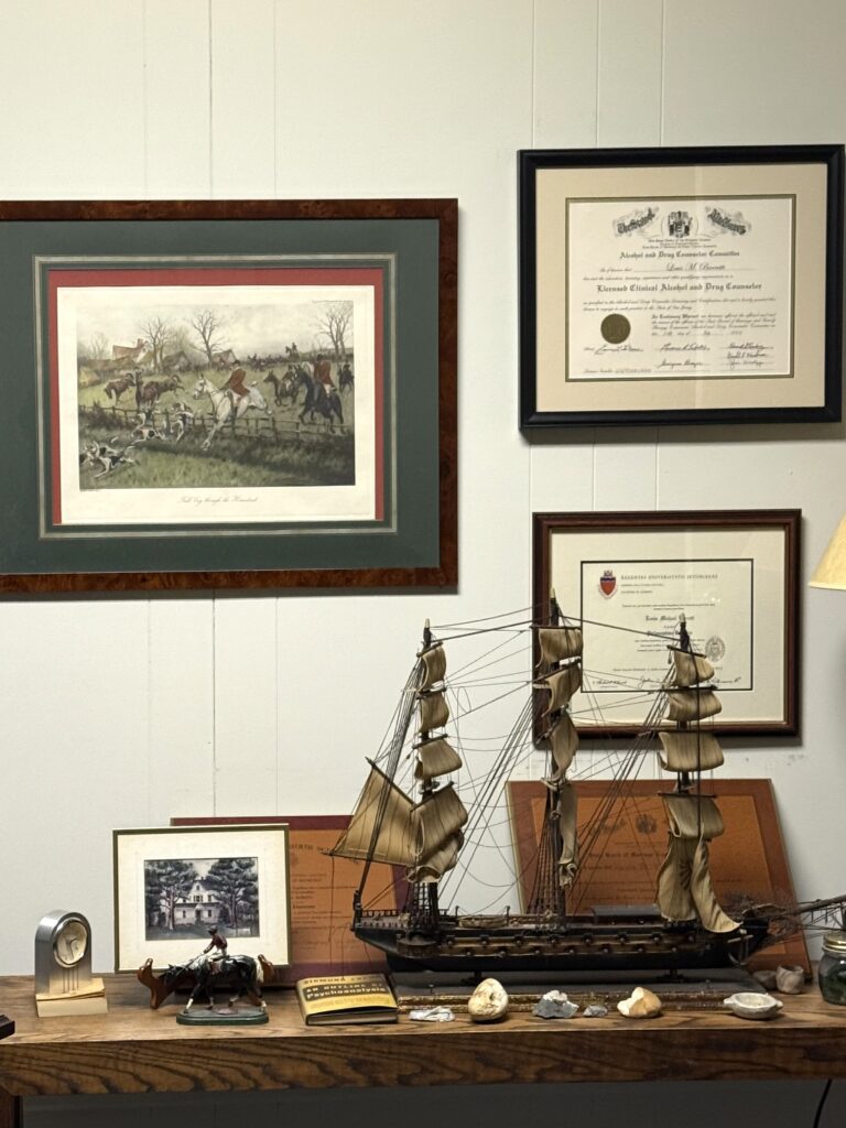 A cozy corner with framed pictures and wooden ship models.